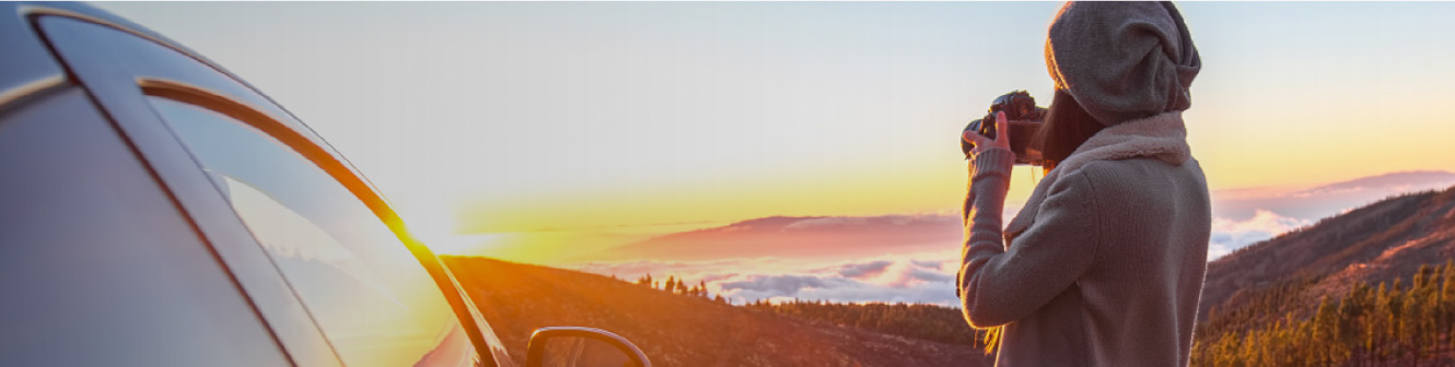 Woman taking picture of sunset in the mountains